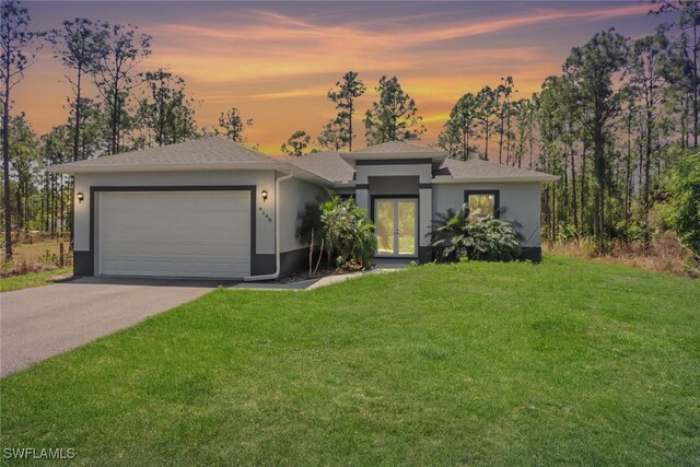 4140 31st Ave NE, Naples, FL 34120 - prairie-style home featuring a lawn, aphalt driveway, french doors, a garage, and stucco siding