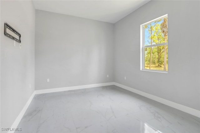 4140 31st Ave NE, Naples, FL 34120 - spare room with marble finish floor, a wealth of natural light, and baseboards