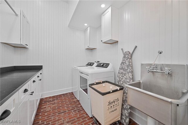 8241 Main St, Bokeelia, FL 33922 - kitchen with independent washer and dryer, brick patterned floors, white cabinets, dark countertops, and baseboards