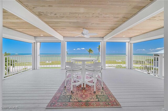8241 Main St, Bokeelia, FL 33922 - wooden deck featuring view of water and beach, ceiling fan, and outdoor dining space