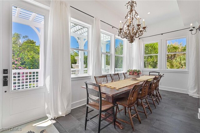 8241 Main St, Bokeelia, FL 33922 - dining room featuring a chandelier, baseboards, and plenty of natural light