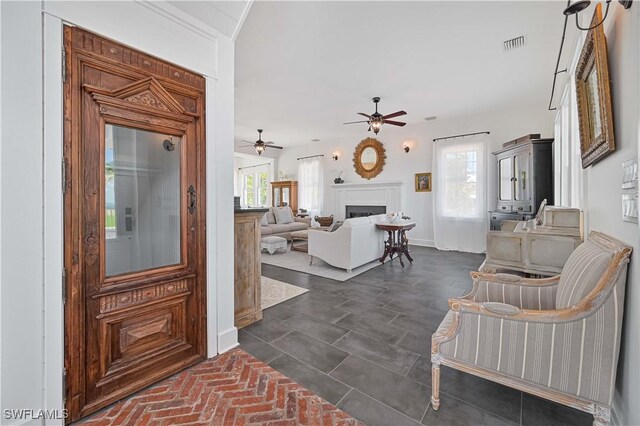 8241 Main St, Bokeelia, FL 33922 - entrance foyer featuring a ceiling fan, a fireplace, and baseboards