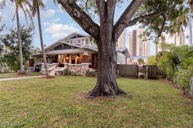 exterior space featuring a porch, fence, and a yard