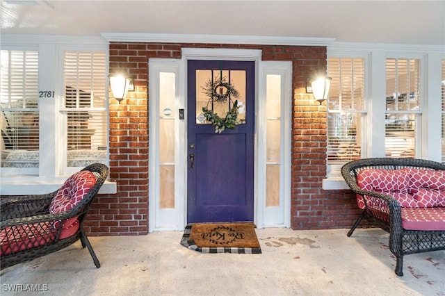 property entrance featuring brick siding and a porch