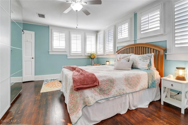 bedroom featuring ceiling fan, baseboards, wood finished floors, and visible vents