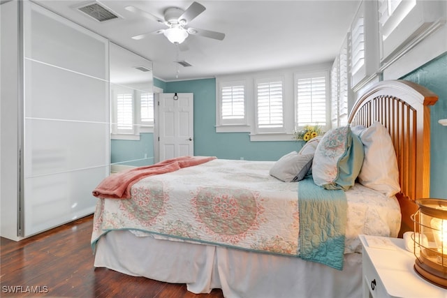 bedroom featuring wood finished floors, visible vents, and a ceiling fan