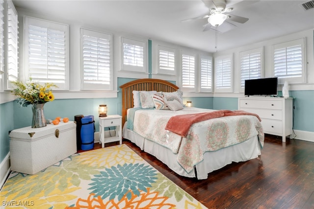 bedroom with baseboards, a ceiling fan, wood finished floors, and visible vents