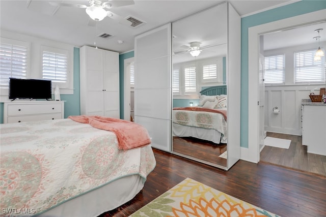 bedroom featuring dark wood-style floors, ceiling fan, visible vents, and a closet
