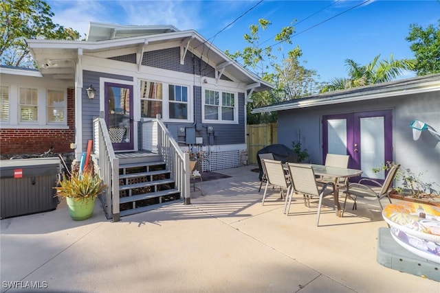 back of house with a patio area, outdoor dining area, a hot tub, and central AC unit