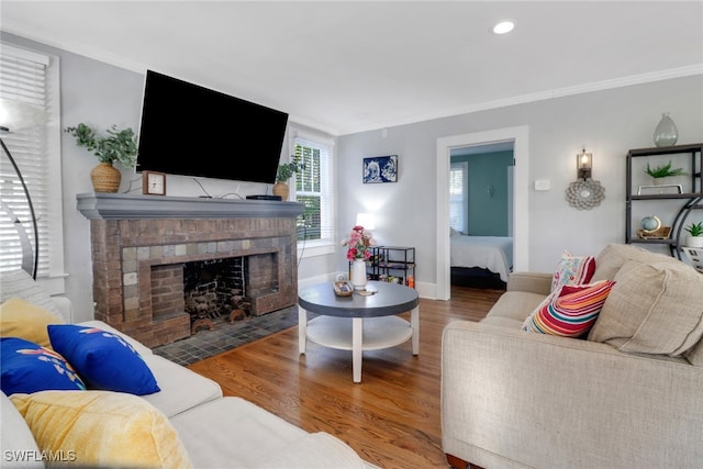 living room with wood finished floors, a fireplace, recessed lighting, and crown molding