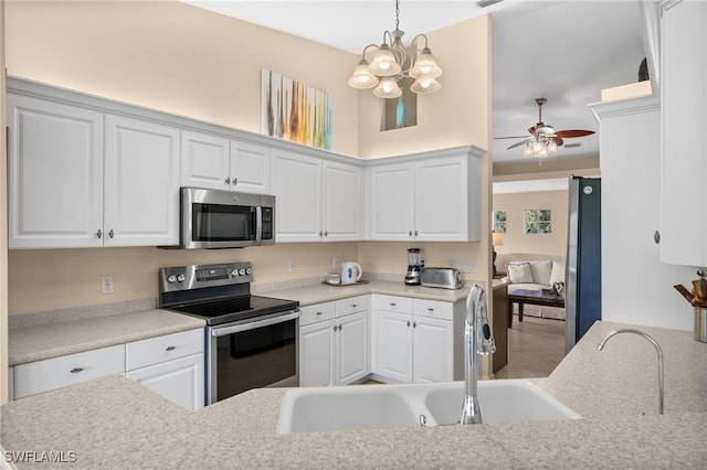 6095 Pinnacle Ln Unit 1304, Naples, FL 34110 - kitchen featuring white cabinets, ceiling fan with notable chandelier, appliances with stainless steel finishes, and a sink