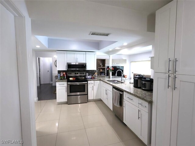 9170 24th Pl, Sunrise, FL 33322 - kitchen with tasteful backsplash, light stone counters, visible vents, appliances with stainless steel finishes, and a sink