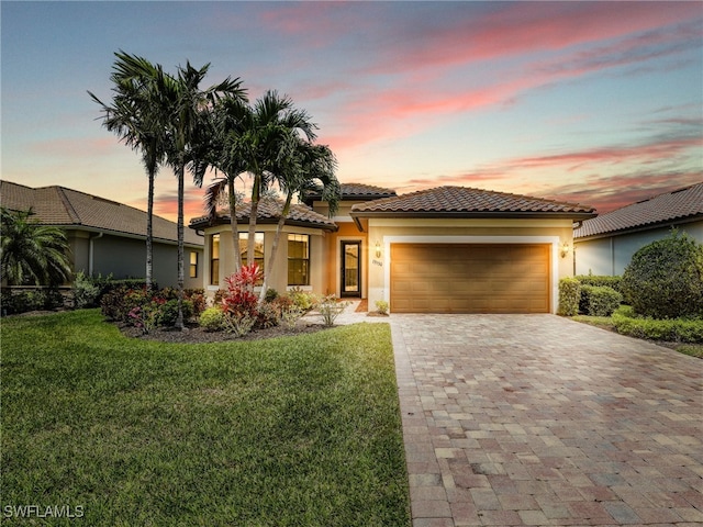 13530 Villa Di Preserve Ln, Estero, FL 33928 - mediterranean / spanish-style house featuring an attached garage, decorative driveway, a front yard, stucco siding, and a tiled roof