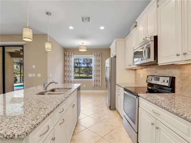 13530 Villa Di Preserve Ln, Estero, FL 33928 - kitchen with stainless steel appliances, decorative backsplash, light tile patterned floors, recessed lighting, and decorative light fixtures