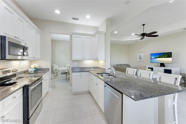 kitchen featuring open floor plan, ceiling fan, a peninsula, appliances with stainless steel finishes, and visible vents