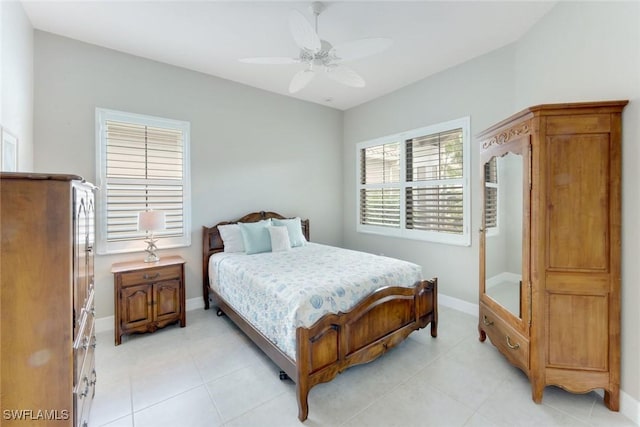 bedroom with ceiling fan, baseboards, and light tile patterned floors