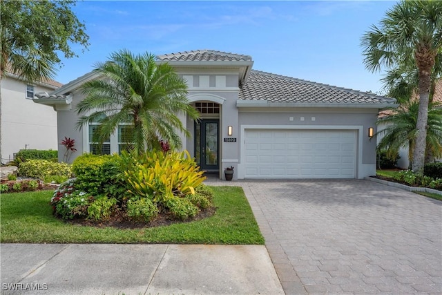 15890 Delasol Ln, Naples, FL 34110 - mediterranean / spanish-style house featuring a tile roof, a garage, decorative driveway, and stucco siding