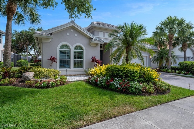 15890 Delasol Ln, Naples, FL 34110 - mediterranean / spanish home with a front yard, driveway, a garage, and stucco siding