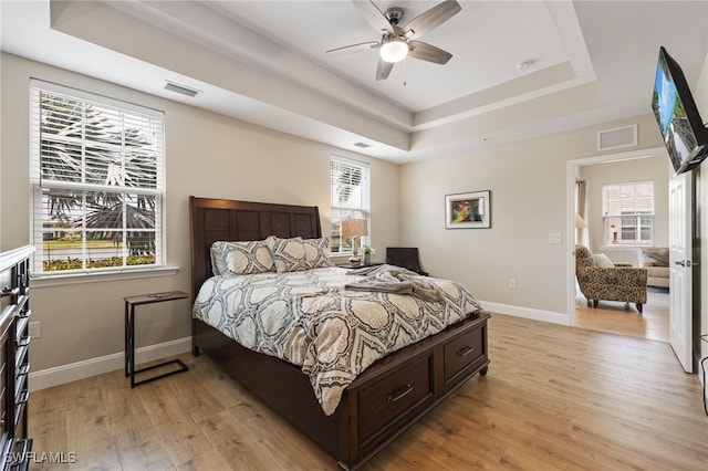 18276 Creekside Preserve Loop Unit 102, Fort Myers, FL 33908 - bedroom featuring a tray ceiling, light wood-style floors, and ceiling fan