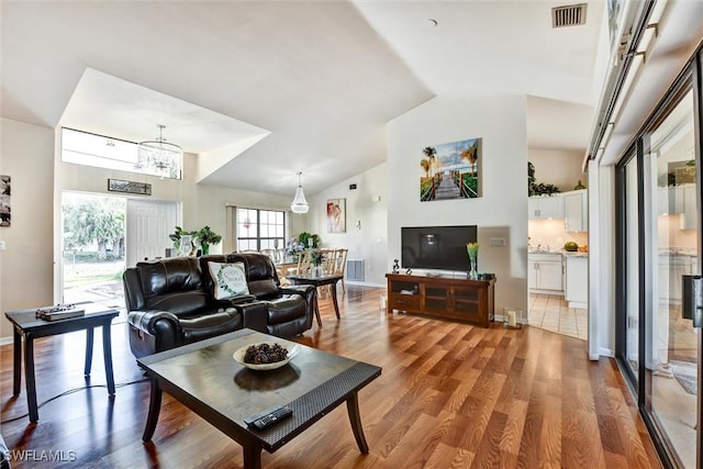 1803 Golfside Village Dr, Lehigh Acres, FL 33936 - living area featuring a chandelier, wood finished floors, high vaulted ceiling, and baseboards