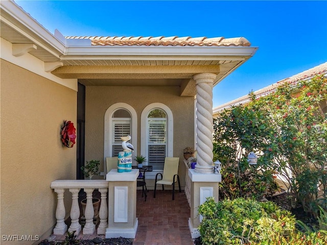 13885 Cleto Dr, Estero, FL 33928 - property entrance featuring a porch, stucco siding, and a tile roof
