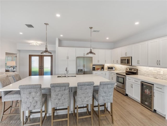 14701 Eden St, Fort Myers, FL 33908 - kitchen featuring a sink, decorative backsplash, stainless steel appliances, wine cooler, and visible vents
