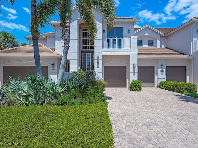 2325 Mont Claire Dr Unit 201, Naples, FL 34109 - view of front of house featuring stucco siding, decorative driveway, a tile roof, a balcony, and an attached garage