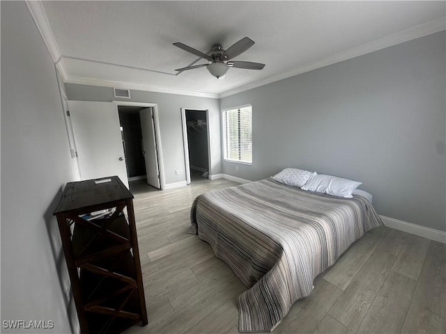 bedroom featuring crown molding, visible vents, and light wood-style floors