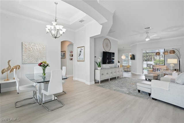 dining space with visible vents, arched walkways, baseboards, light wood-style floors, and ornamental molding