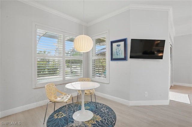 dining space with baseboards, ornamental molding, and wood finished floors