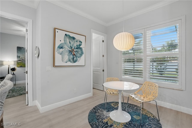 dining area with baseboards, ornamental molding, and light wood-style floors