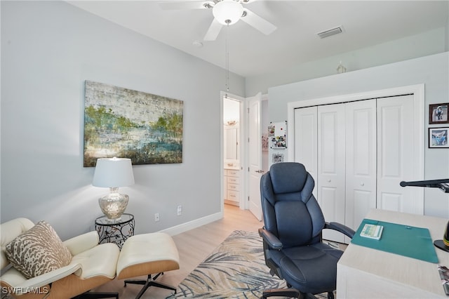 office area with baseboards, a ceiling fan, light wood finished floors, and visible vents