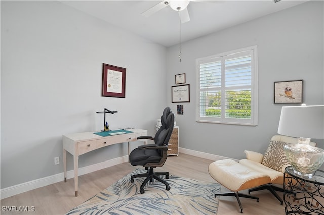 office space with baseboards, a ceiling fan, and light wood-type flooring