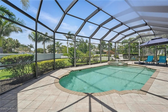 view of swimming pool with glass enclosure, a pool with connected hot tub, and a patio area