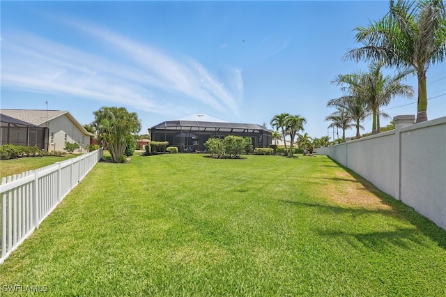 view of yard featuring a fenced backyard and glass enclosure