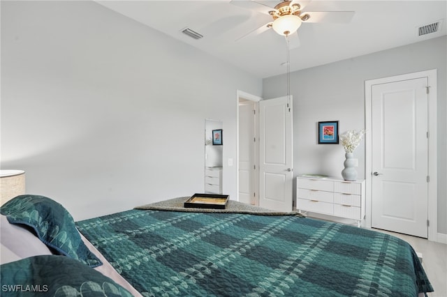bedroom with ceiling fan, wood finished floors, and visible vents