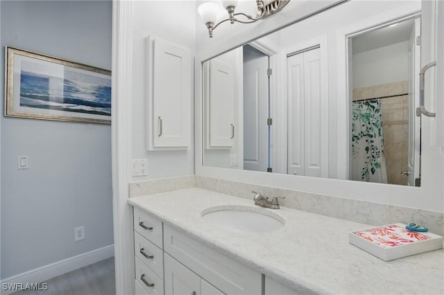 bathroom with vanity, baseboards, a shower with shower curtain, and a chandelier