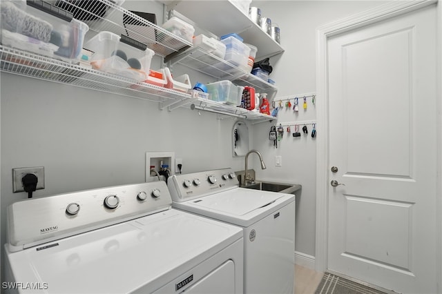 washroom featuring independent washer and dryer, laundry area, and a sink
