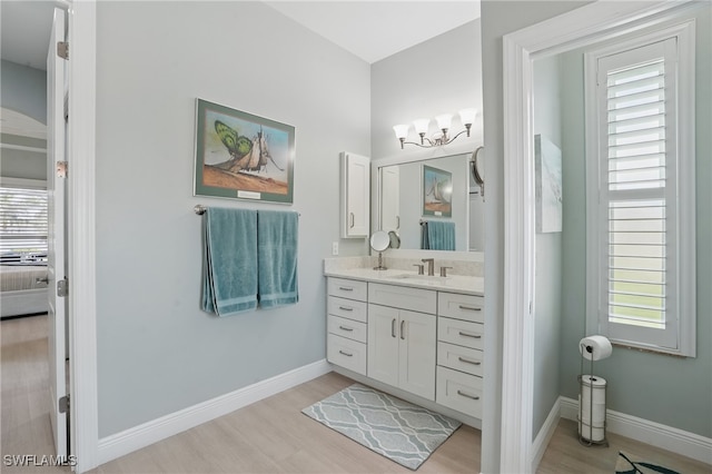 bathroom with baseboards, ensuite bathroom, wood finished floors, and vanity