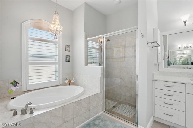 bathroom with an inviting chandelier, a shower stall, and a garden tub