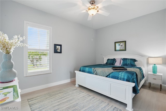 bedroom featuring baseboards, ceiling fan, and light wood-style floors