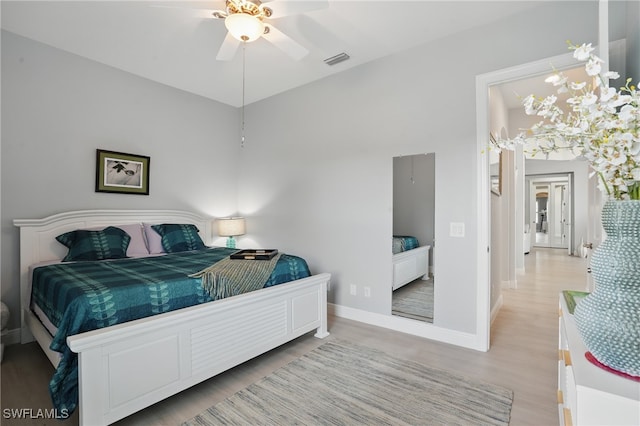 bedroom with visible vents, baseboards, and wood finished floors