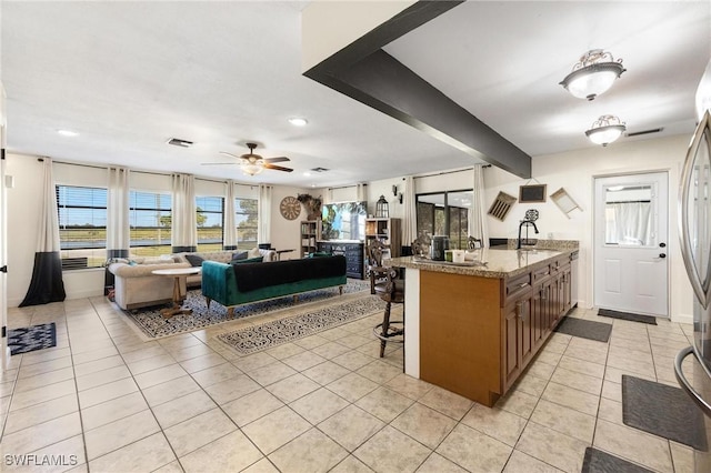 kitchen featuring visible vents, light tile patterned floors, ceiling fan, a kitchen bar, and recessed lighting