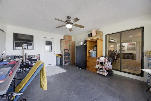 office featuring a textured ceiling, concrete floors, and a ceiling fan