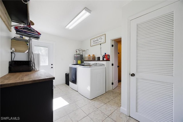 laundry area featuring laundry area, washing machine and clothes dryer, light tile patterned floors, and water heater