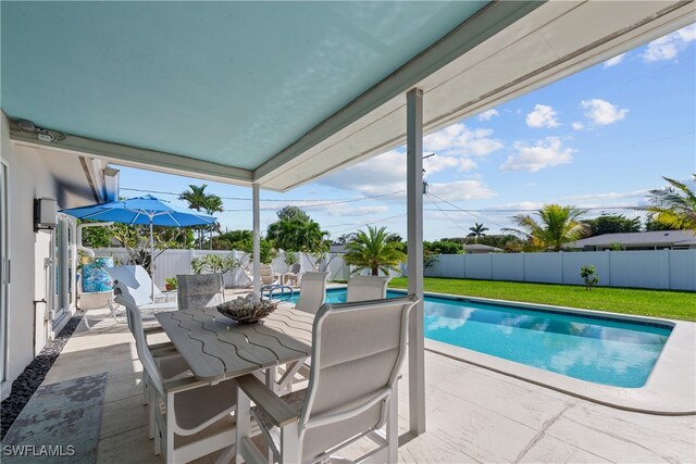 view of pool with a fenced in pool, a patio, outdoor dining space, a fenced backyard, and a lawn