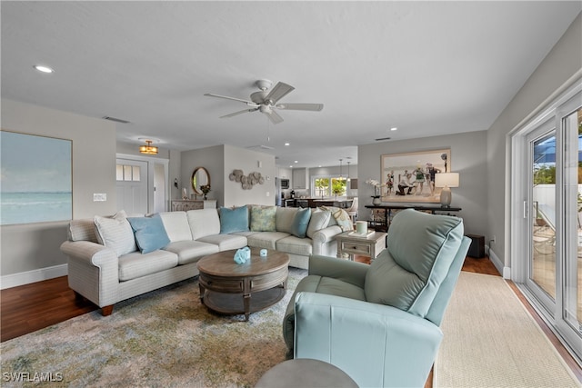 living room with ceiling fan, visible vents, recessed lighting, wood finished floors, and baseboards