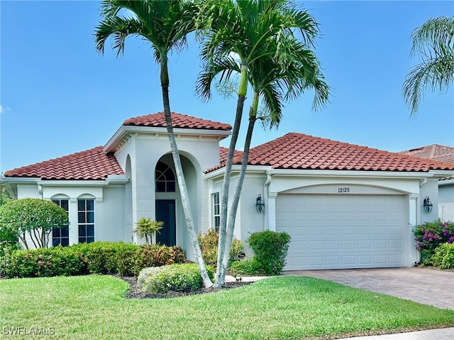 12125 Via Cercina Dr, Bonita Springs, FL 34135 - mediterranean / spanish home featuring an attached garage, driveway, a front lawn, and stucco siding