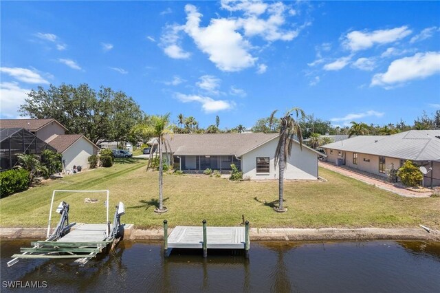 6181 Plumosa Ave, Fort Myers, FL 33908 - rear view of property featuring a lawn, a water view, boat lift, stucco siding, and a residential view