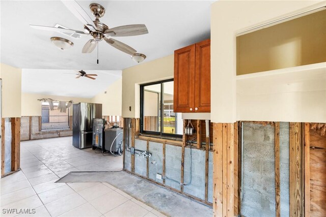 6181 Plumosa Ave, Fort Myers, FL 33908 - kitchen featuring light tile patterned flooring, freestanding refrigerator, brown cabinetry, and ceiling fan